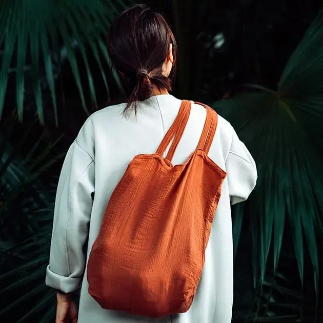donna di spalle con una borsa di tela